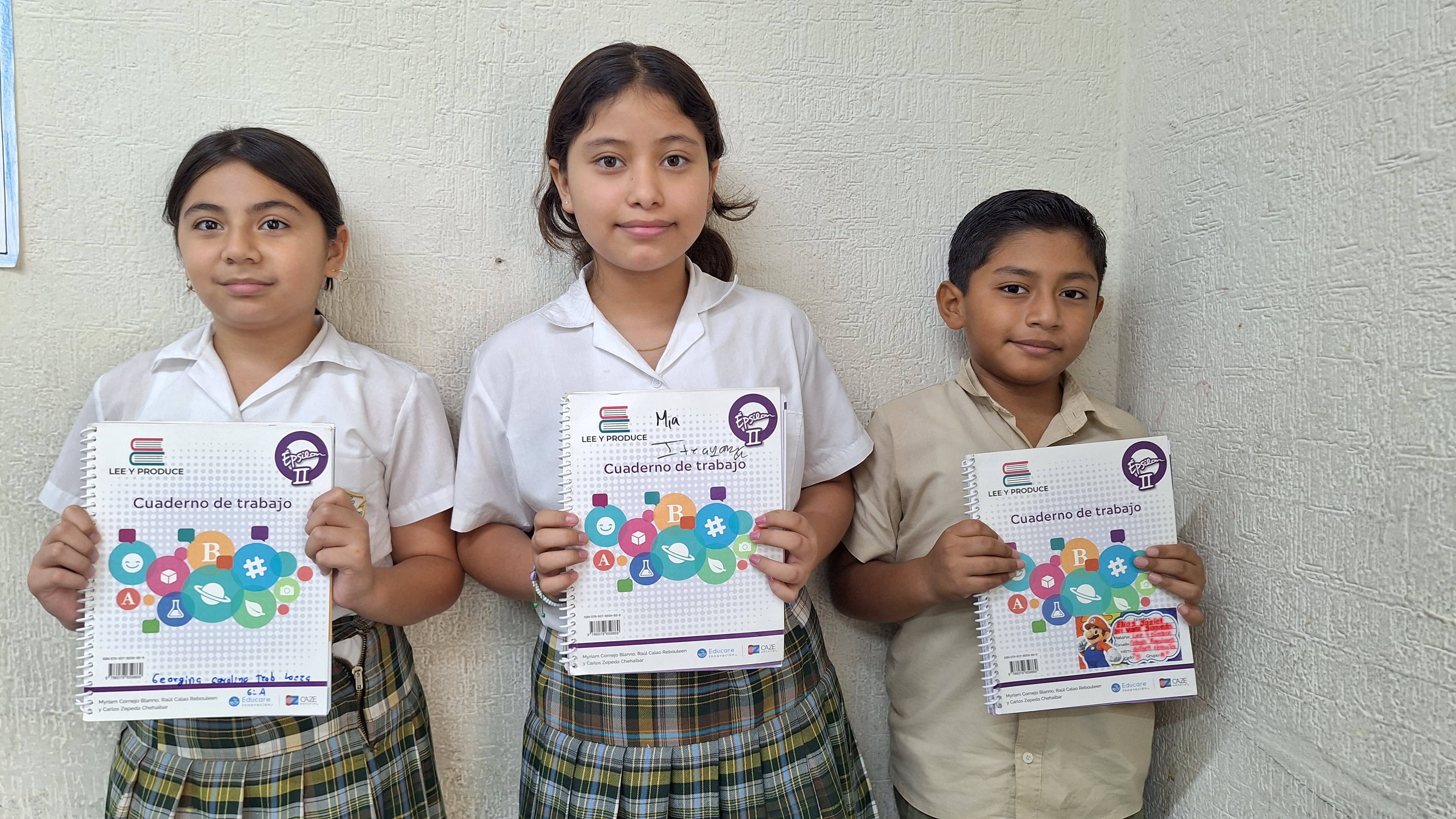 Alumnos del colegio americano de mérida mostrando su cuaderno de trabajo del programa lee y produce
