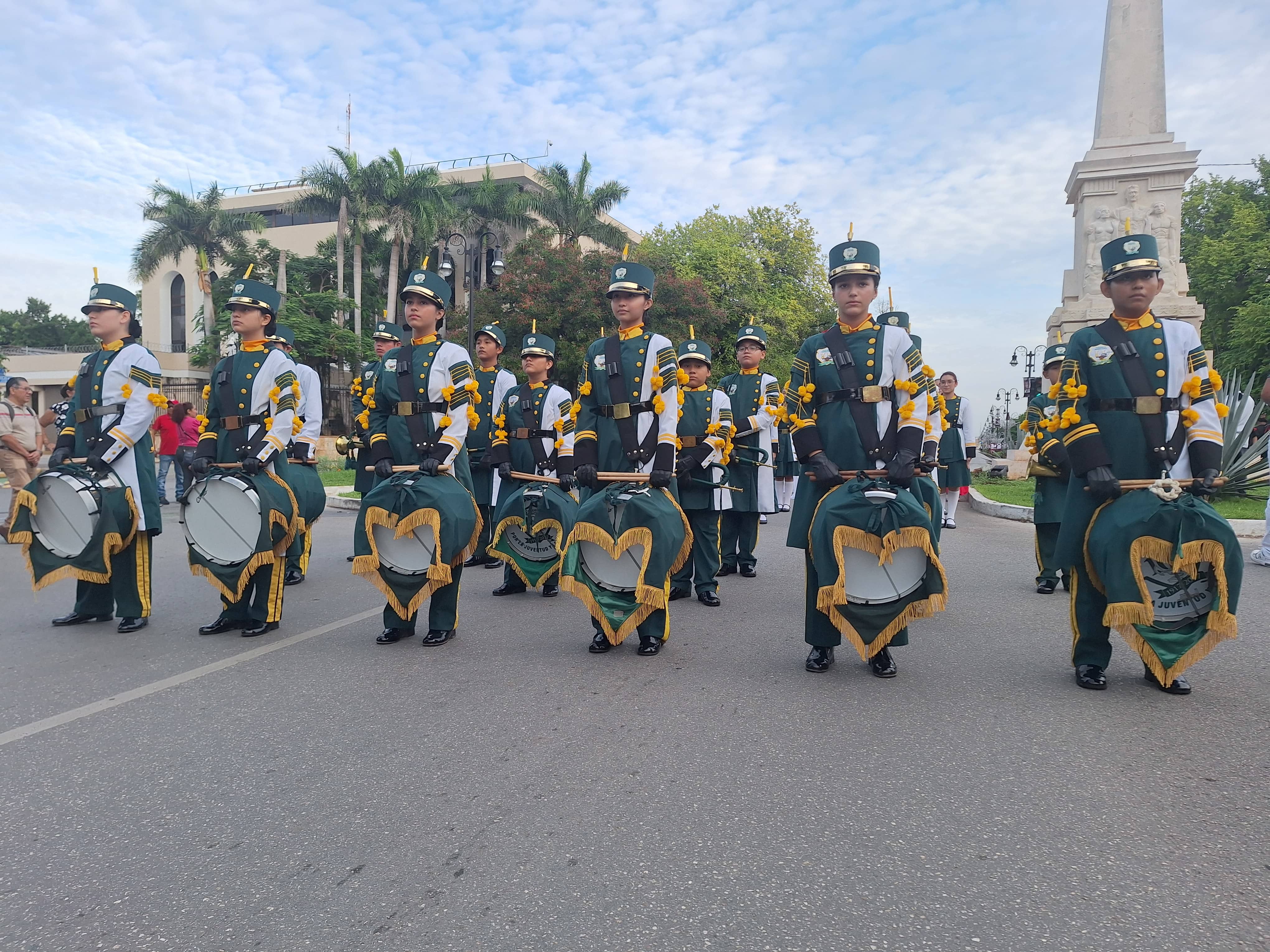 Estudiantes de banda de guerra del colegio americano uniformados y participando en evento en Mérida